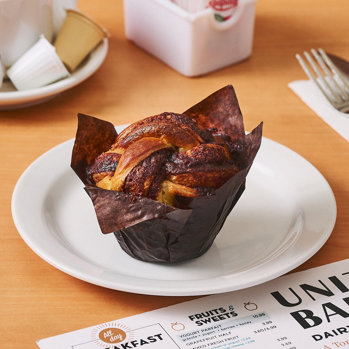 Cinnamon Babke Knot on a white plate with a United Bakers menu underneath